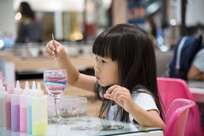 Close-up of girl sitting on table