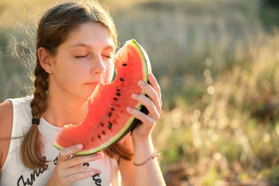 Portrait of happy young woman enjoing and eating watermelon outdoors, slow life. summer lifestyle 