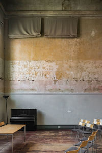 Grand piano, or normal piano, in a vintage room, unpainted walls, with dirt and humidity