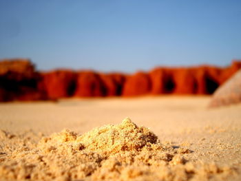 Close-up of sand against clear sky