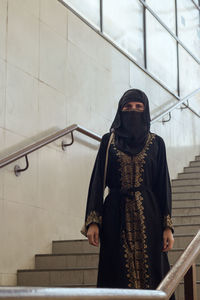 Portrait of man standing against staircase