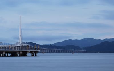 View of bridge over water against cloudy sky