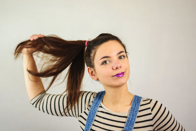 Portrait of young woman against beige background