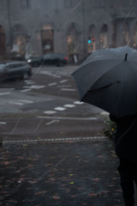 Man standing on wet street in rain