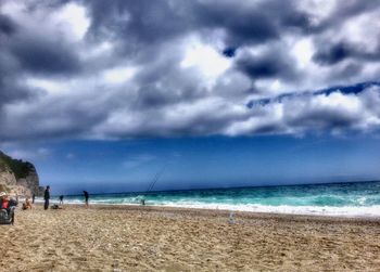 Scenic view of beach against cloudy sky