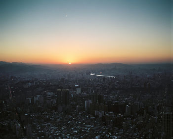 High angle view of illuminated cityscape against sky during sunset