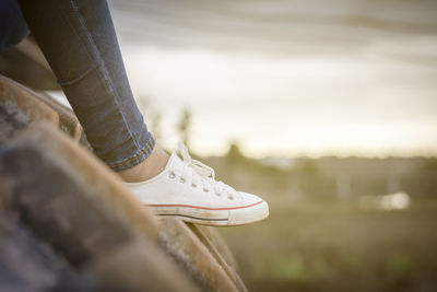 Low section of woman sitting on metallic wheel