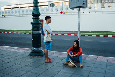 Full length portrait of young woman on tiled floor