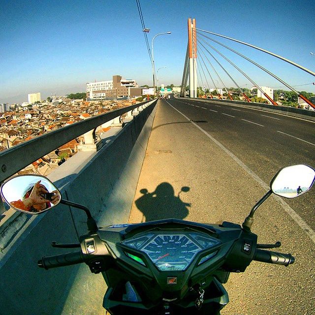 architecture, transportation, built structure, clear sky, connection, bridge - man made structure, road, sky, city, building exterior, engineering, travel, land vehicle, car, metal, travel destinations, blue, the way forward, sunlight, diminishing perspective