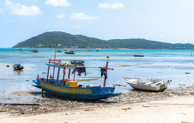 Boats moored on beach against sky