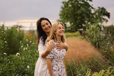 A young mother with a teenage daughter spends time in the garden. family holiday and togetherness.