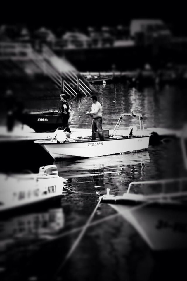 water, selective focus, men, nautical vessel, transportation, bird, lifestyles, river, lake, leisure activity, reflection, boat, animals in the wild, outdoors, pier, focus on foreground, wildlife, person