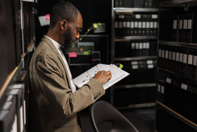 Side view of young man using phone