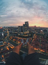 Low section of man and cityscape against sky