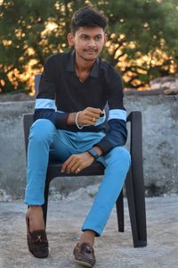 Portrait of young man sitting on bench