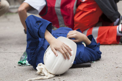 Paramedic performing cpr on person lying on street