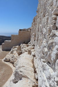 Rock formations by sea against clear sky