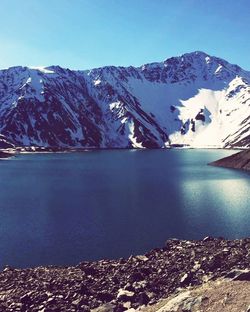 Scenic view of lake and snowcapped mountains against sky