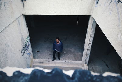 High angle portrait of woman standing against wall