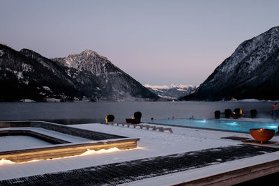 Scenic view of lake by mountains against clear sky