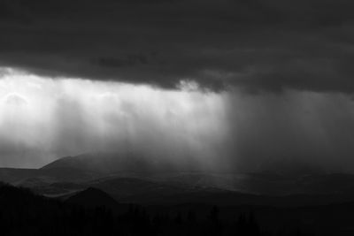 Scenic view of mountains against storm clouds