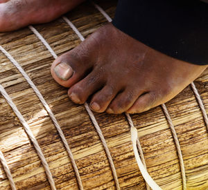 Low section of person standing tied straw bundle