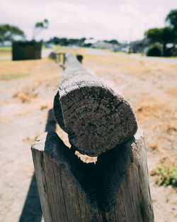 Close-up of damaged wooden post on field