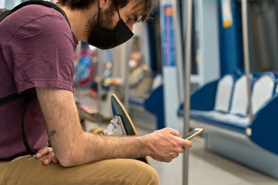 Midsection of man using mobile phone