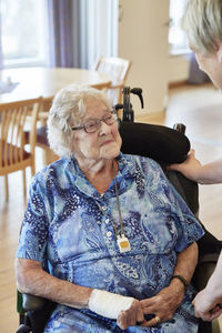 Nurse in care home talking with senior woman