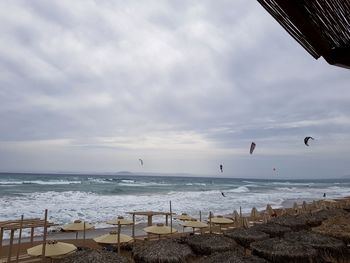Birds flying over beach against sky