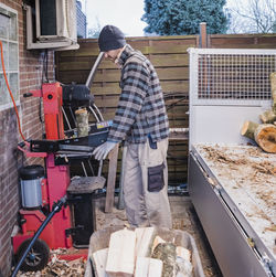 Side view of man cutting wood