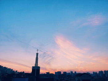 Silhouette of buildings against cloudy sky