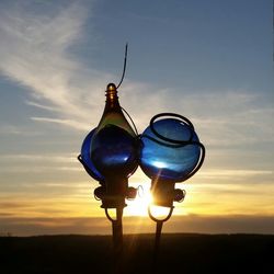 Silhouette lamp against sky during sunset