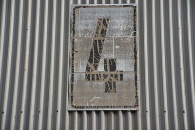 Close-up of text on metal wall of building