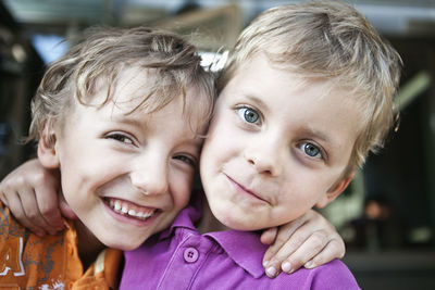 Portrait of a two playful brothers with arms around