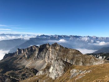 Scenic view of mountains against blue sky