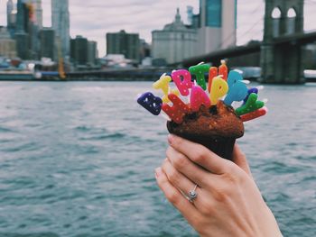 Midsection of person holding ice cream in city