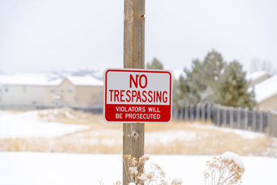 Warning sign against sky during winter