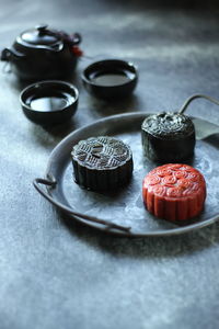 Close-up of traditional red and black mooncake on the rough grey texture table.