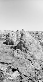 Rocks on beach against clear sky