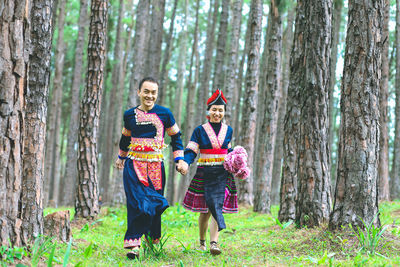 Full length portrait of happy friends in forest