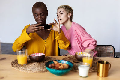 Portrait of smiling young woman having food at home