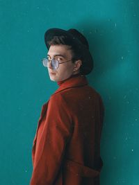 Portrait of boy standing against blue wall