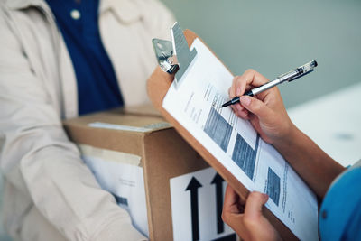 Midsection of businessman holding paper