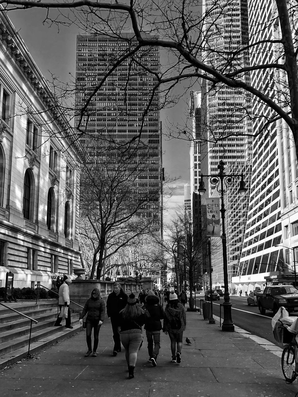 PEOPLE WALKING ON ROAD AGAINST BUILDINGS