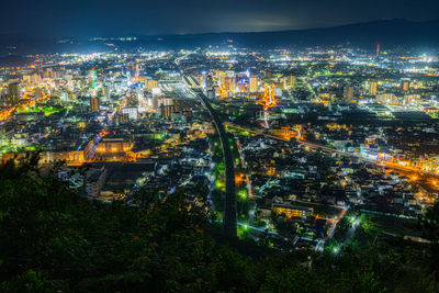 High angle view of illuminated cityscape against sky at night