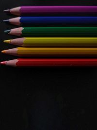 High angle view of colored pencils against black background