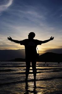 Rear view of silhouette person standing on beach