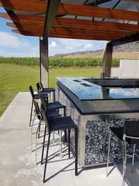 Chairs and table on field against sky