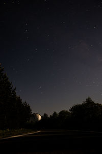 Silhouette trees against sky at night